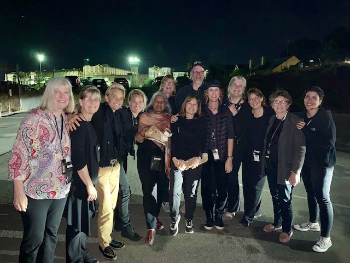 Group of people posing together at night in a parking lot.