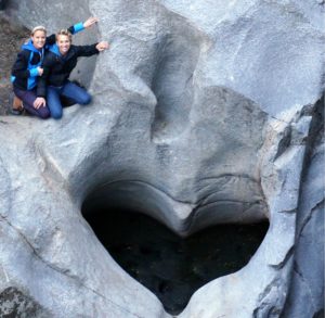 picture of heart shaped rock with Hilary & Kim next to it