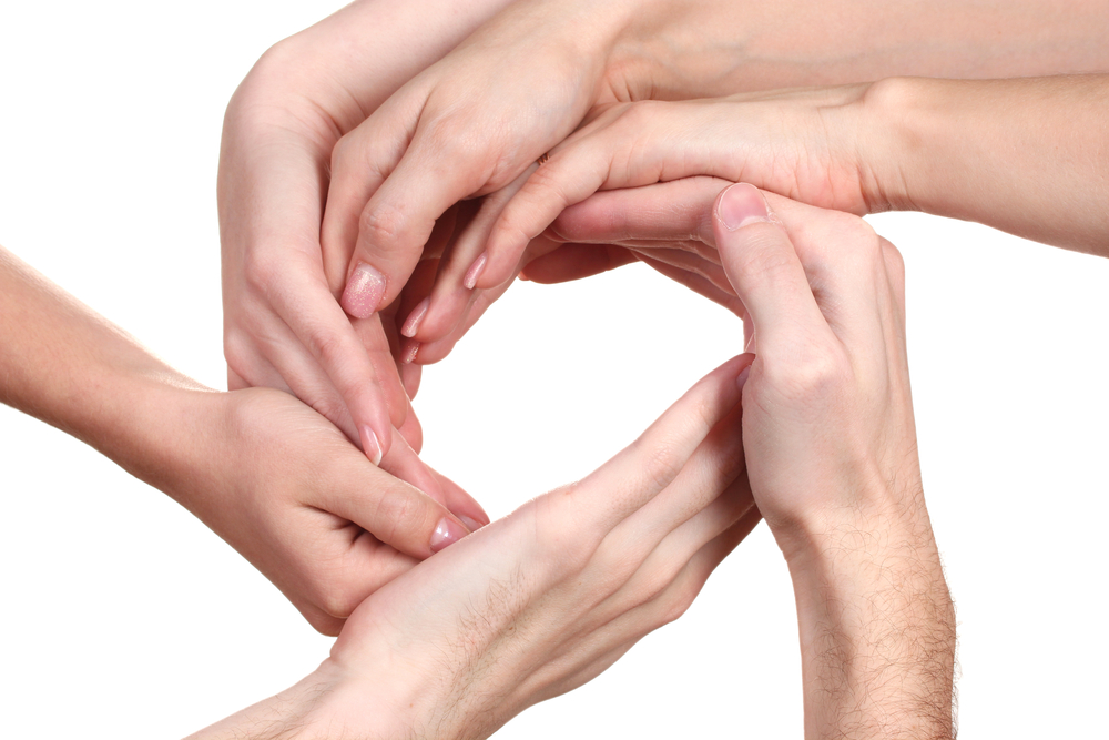 Several hands forming a circle with their index fingers and thumbs connected.