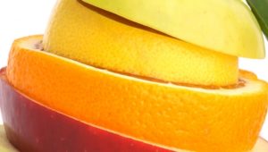 Slices of fruit arranged in a stack with an apple at the bottom, an orange in the middle, and a banana on top.