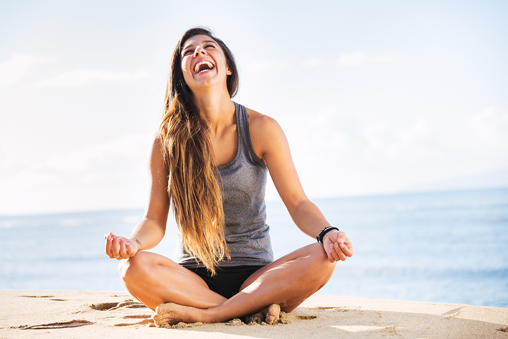 Young woman practicing morning meditation in nature at the beach