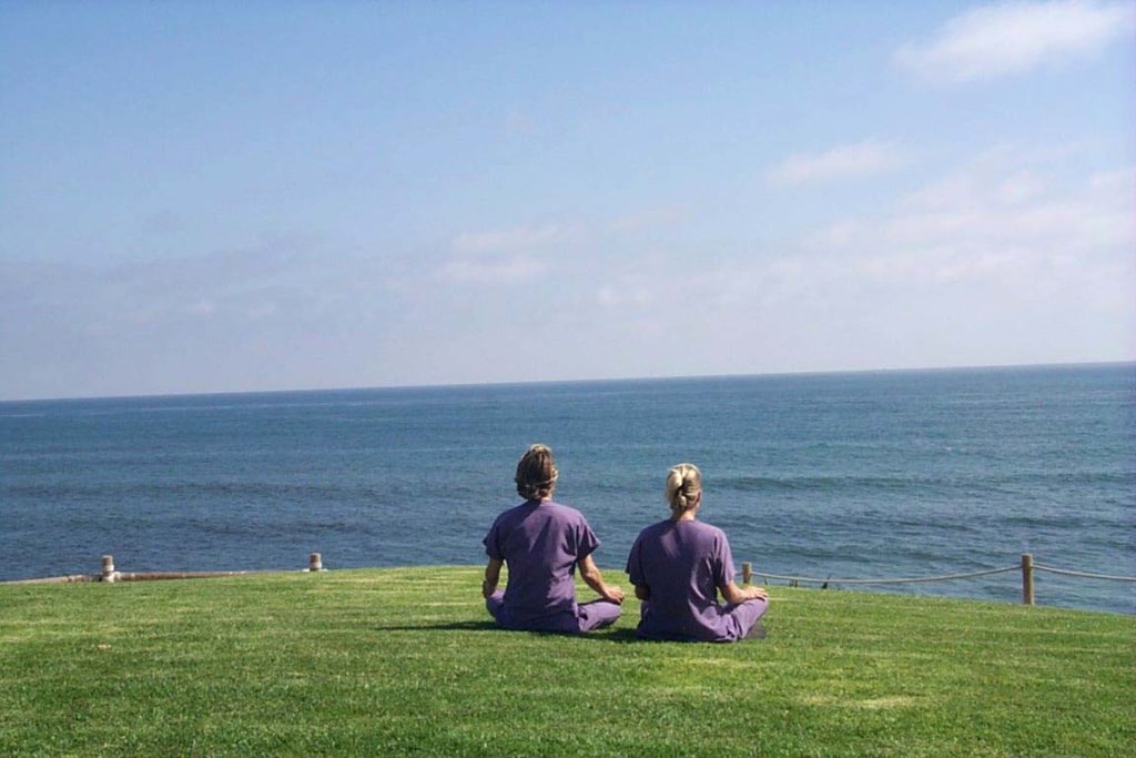 image of Dr Hilary and Dr Kim meditating in front of ocean at Sanoviv Medical Institute