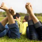 Conscious Relationships image of a couple on the grass talking