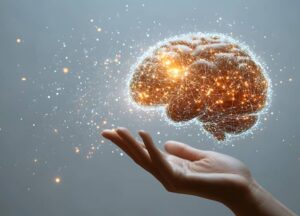 What is Online Brainspotting? A hand is held palm up beneath a glowing digital rendering of a human brain, surrounded by interconnected lights and lines, against a neutral background.