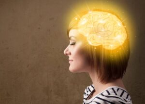 Brainspotting: A Beginners Guide A woman in profile with an illustrated glowing brain superimposed over her head, symbolizing creativity or intelligence.